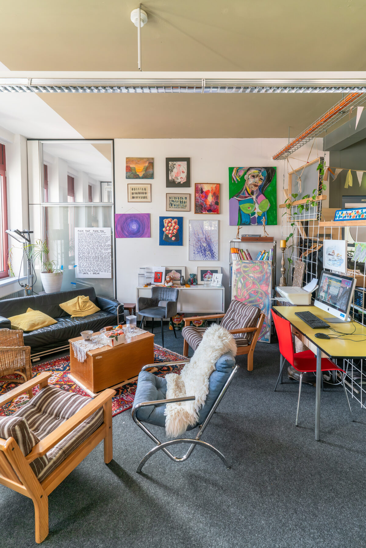 Credits Martin Zeller 3 Ein gemütliches Wohnzimmer mit Sofa, Sessel, Kunstwerken und Arbeitsplatz.
