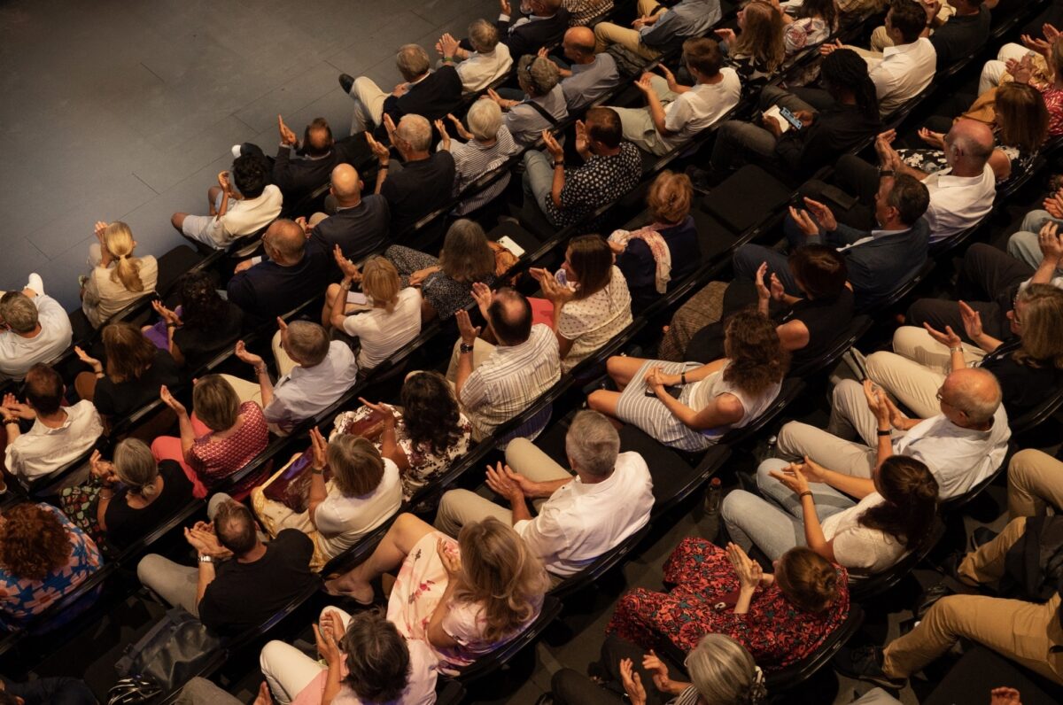 GI beider Basel Eine Gruppe von Menschen klatscht in einem Auditorium.