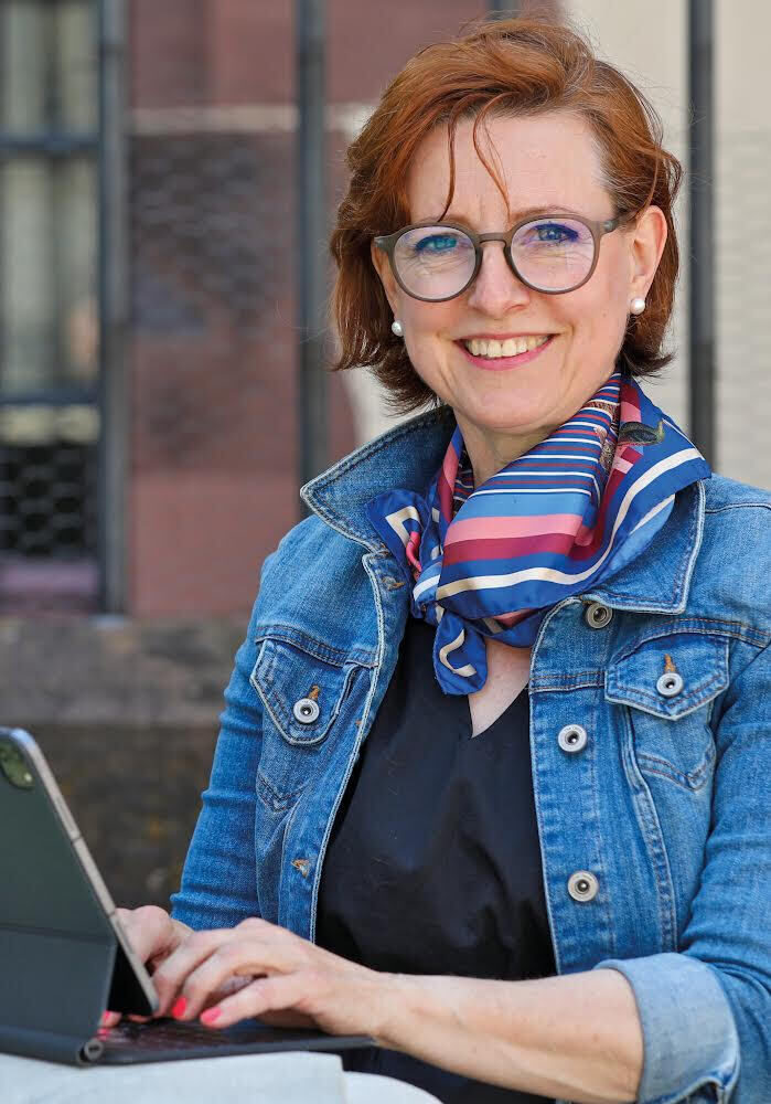 Andrea Knellwolf keine Quellenangabe 1 Eine lächelnde Frau mit Brille arbeitet an einem Laptop.