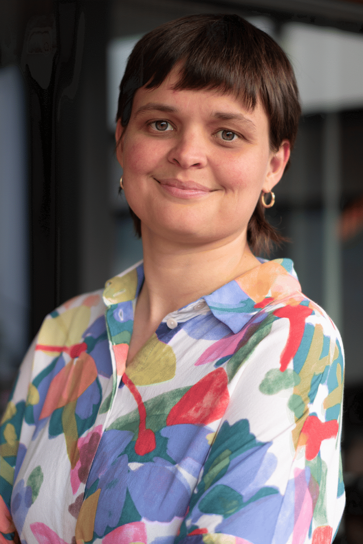 Marian Lara Rubin 1 Eine lächelnde Person mit kurzem Haar und buntem Hemd.